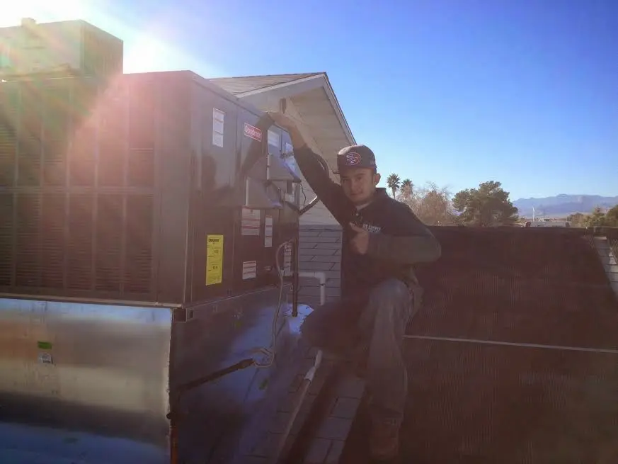 HVAC technician performing Air Duct Cleaning on a rooftop unit in Xenia